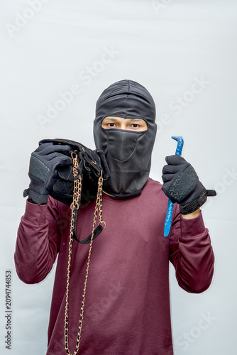 Photos Masked thief holding stolen gold chain