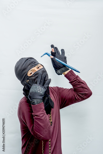 Fotografi Thief wearing a balaclava holding a crowbar