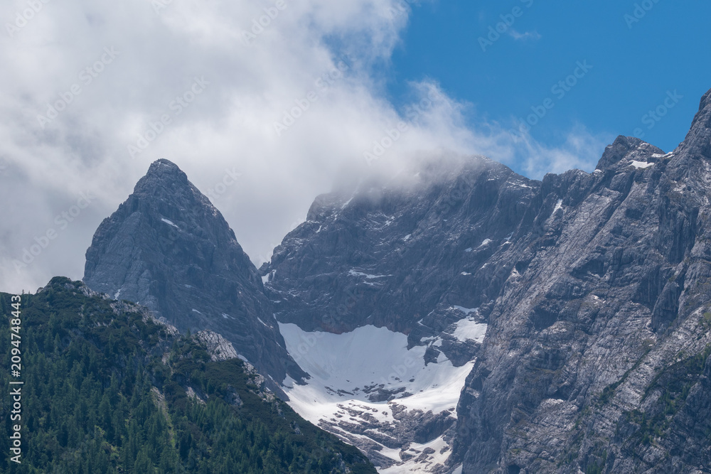 Obraz premium Scenic view of the Blaueisgletscher glacier nestled between the rugged limestone peaks of the Hochkalter massif, Berchtesgaden Alps, Germany