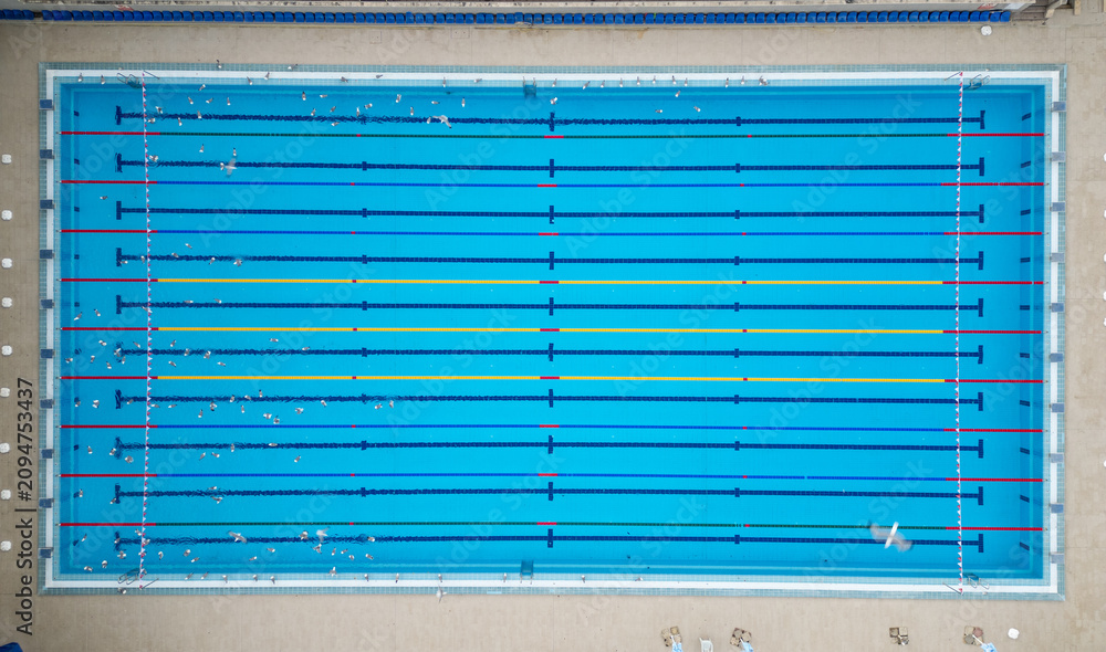 Fototapeta premium Aerial top down view of a water polo match in an outdoor swimming pool