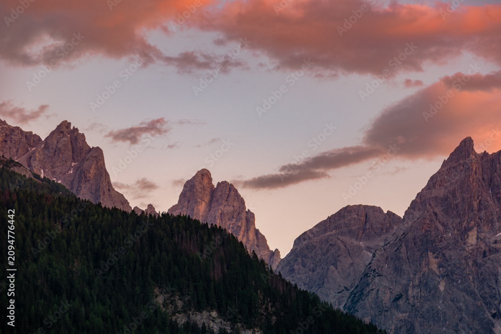 Obraz premium Stunning sunset over the mountain ridge of Rotwandwiesen in the Drei Zinnen Nature Park, showing jagged peaks lit by glowing pink clouds at dusk, Dolomites, South Tyrol, Italy