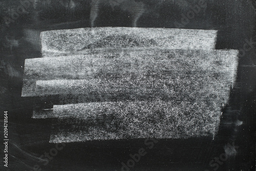 Dark chalkboard texture with dust and scratches. Messy chalk dust and smudges, grunge background with empty space for text.