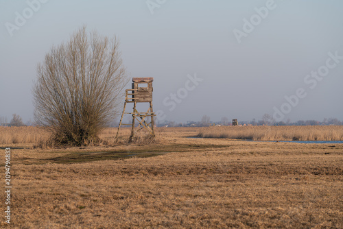 Wooden hunting tower surrounded by seasonally flooded wetlands at sunrise in the Sludwia and Przysowa Valley near Złaków Kościelny, Poland