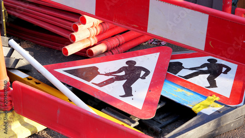Photos Roadworks signs, temporary safety barriers, road construction site with warning