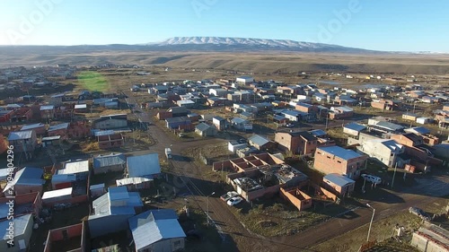 4K aerial drone footage flying over 28 de Noviembre, a Patagonian town in Santa Cruz, Argentina. Scenic mountain surroundings, residential neighborhoods, and the unique landscape of southern Patagonia