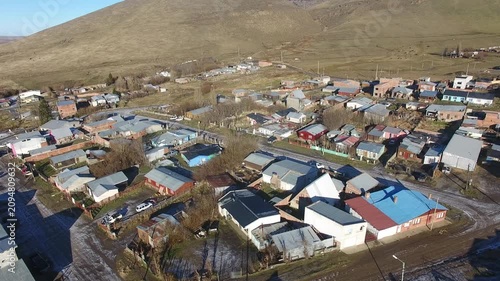 4K aerial drone footage flying over Julia Dufour, a Patagonian mining town in Santa Cruz, Argentina. Scenic urban landscape surrounded by rugged mountains, showcasing the beauty of southern Patagonia.