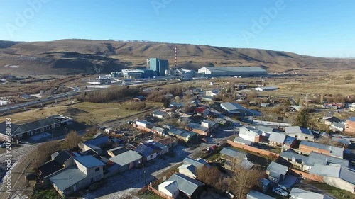 4K aerial drone footage flying over Julia Dufour, a Patagonian megausina in Santa Cruz, Argentina. Scenic urban landscape surrounded by rugged mountains, showcasing the beauty of southern Patagonia.