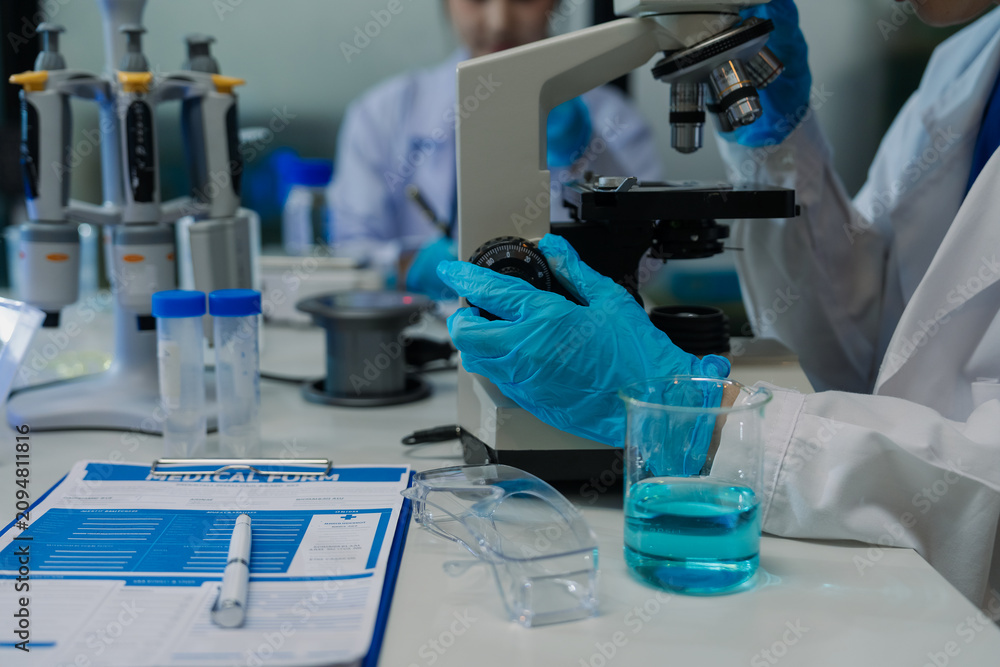 Fototapeta premium A team of scientists is analyzing data and testing samples in a modern biochemistry laboratory.