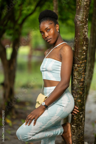 Portrait of an African lady leaning against. tree