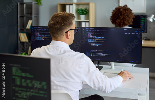 Foto Programmer developer coding software monitors office computer