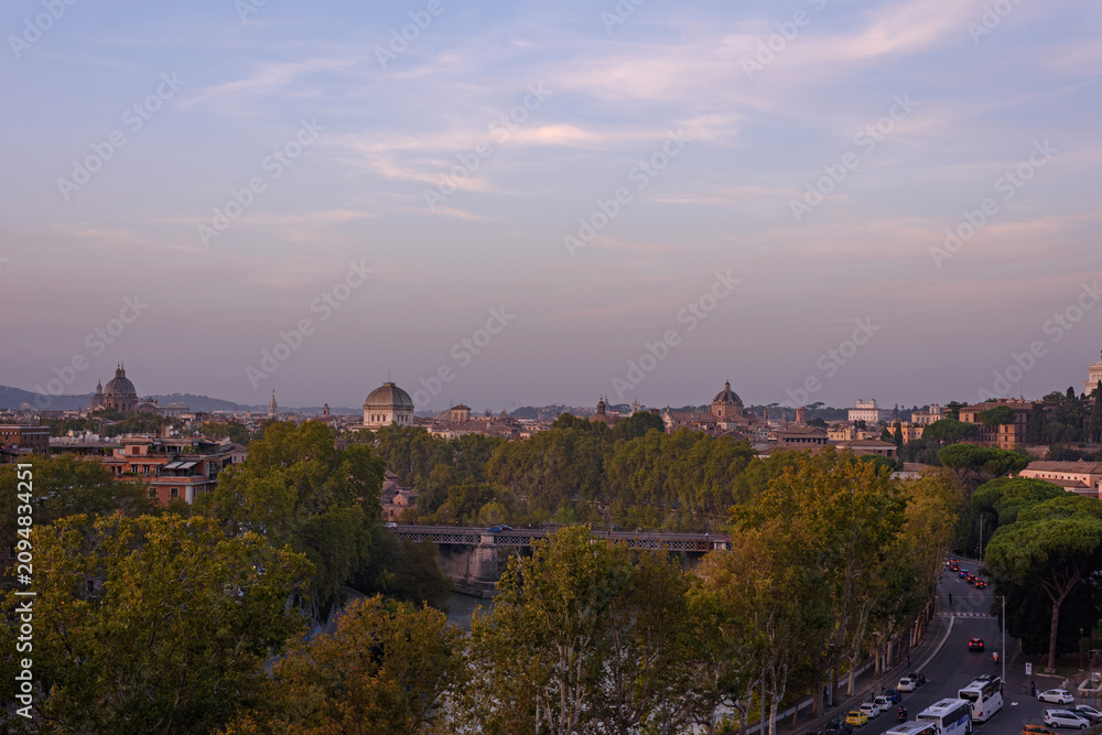 Fototapeta premium Panoramic evening view of Rome cityscape at twilight with the Tiber River, Palatino bridge, and historic landmarks