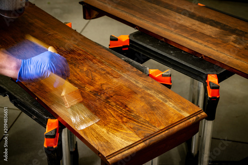 Brushing a layer of Polyurethane finish on cherry wood
