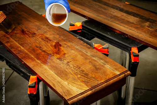 Master craftsman applies Polyurethane to a tabletop