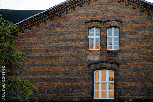 Obraz na plátně An old brick building with windows, seen from below