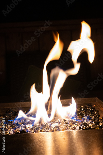 Mesmerizing Outdoor Gas Fire Pit with Reflective Black Fire Glass at Night.