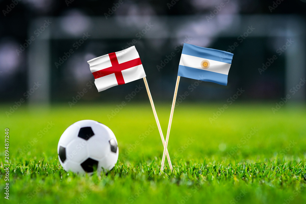 Obraz premium England vs Argentina, Semifinals, national flags before international football match, football on green grass with stadium in the background, Atlanta, July 15, 2026.
