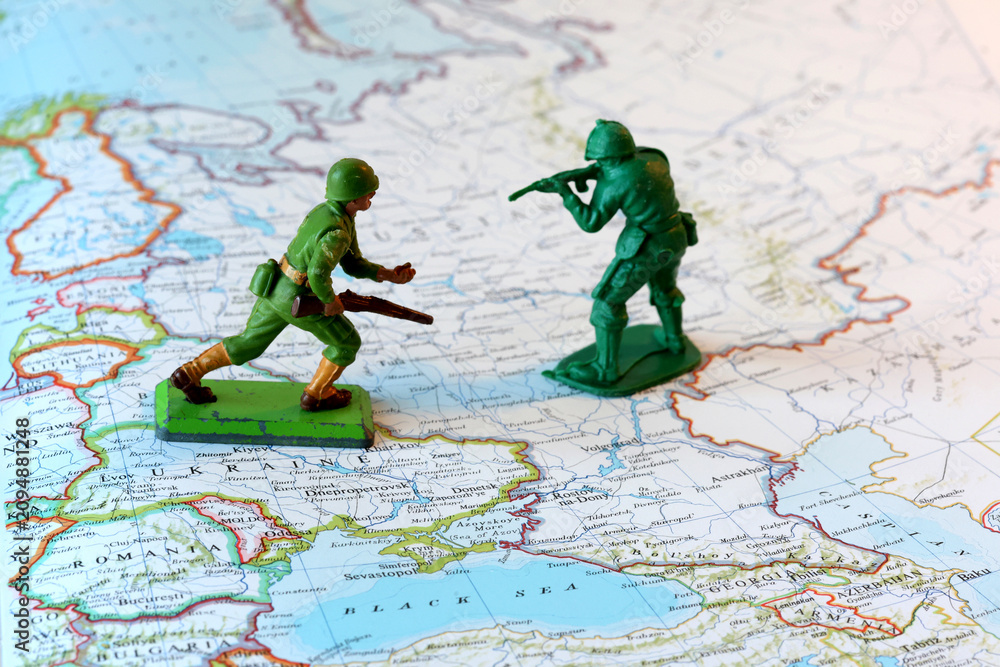 Fototapeta premium Miniature Soldiers Facing Off Over Ukraine on a World Map