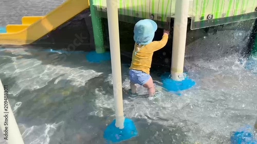 Toddler enjoying summer fun at the water park playground