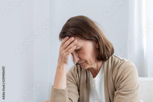 Mature woman has her hand on her forehead suffer from headache