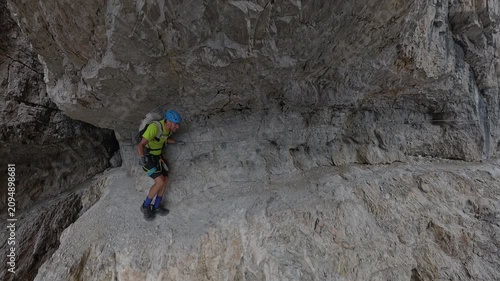Hiker passing beneath a narrow rock passage on Via Ferrata Bocchette Centrali, Brenta Dolomites