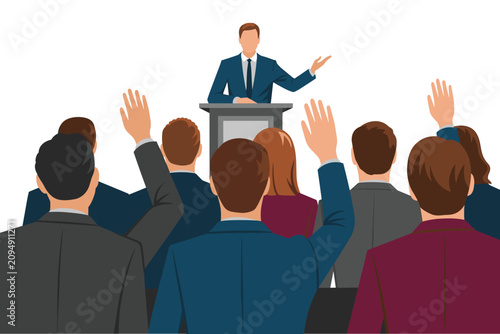 Business conference with a speaker at the podium and audience raising hands