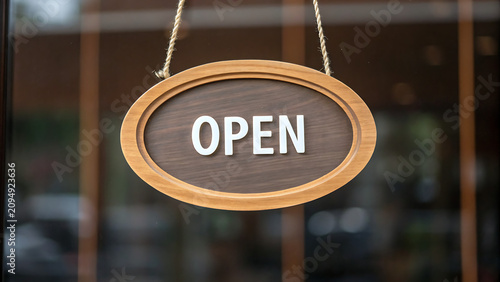 Open sign hanging on storefront door. Retail business welcoming customers with illuminated store hours. Small shop ready for commerce and foot traf...