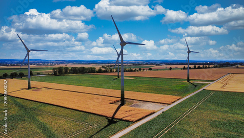 Windkraftanlagen über deutschen Feldern unter blauem Himmel