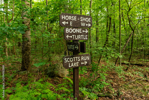 Wooden trail sign marking hiking routes through the forest at French Creek State Park, Pennsylvania.