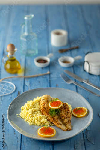Grilled fish fillet with couscous, caviar, and fresh lemon