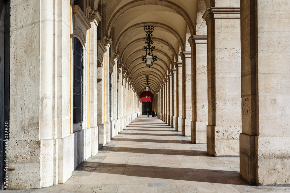 Obraz premium Vaulted ceiling with ornate iron lamps hanging in courtyard walkway