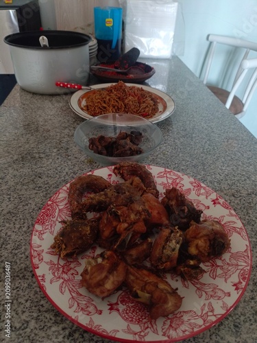 Delicious homemade meal featuring fried chicken and spaghetti served on a granite countertop, perfect for a family dinner