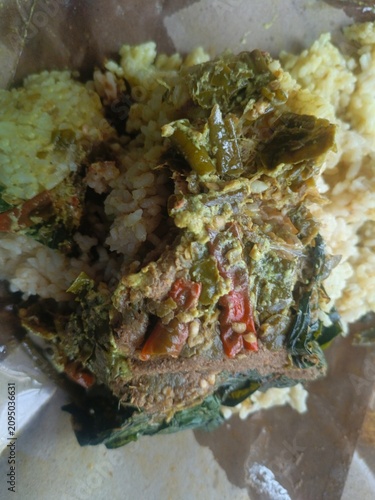 Savory Meal nasi padang Wrapped in Paper.  Indonesian padang food or nasi bungkus with beef rendang, casava leaf, green chili sauce. Semarang, 12-07-2026
