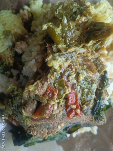 Savory Meal nasi padang Wrapped in Paper.  Indonesian padang food or nasi bungkus with beef rendang, casava leaf, green chili sauce. Semarang, 12-07-2026