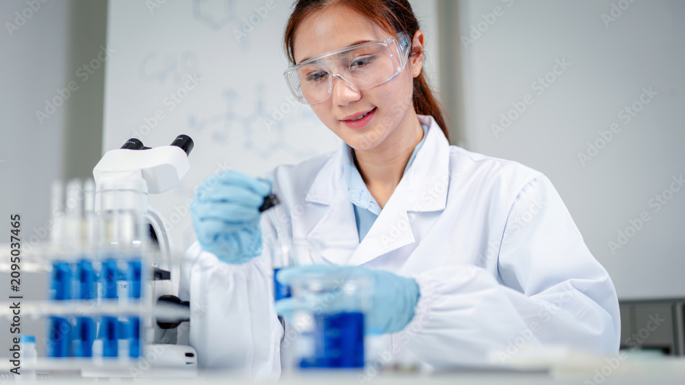 Fototapeta premium Professional scientist conducts rigorous laboratory analysis preparing blue liquid solution for medical development with advanced research equipment