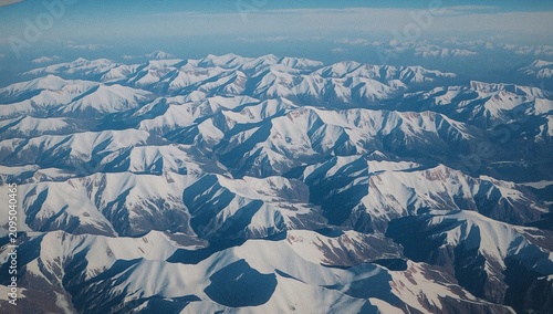 Snowy Mountains View Taken From Airplane During Flight High Above Landscape