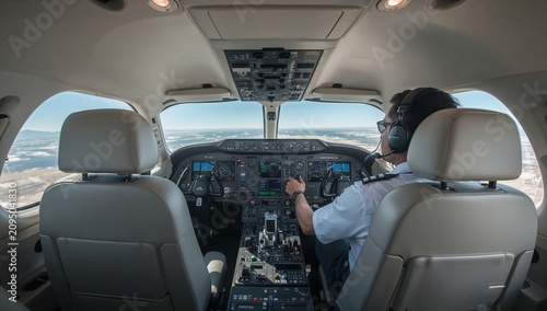 Pilot Operates Aircraft in Flight During Daytime With Clear Skies Above Mount...