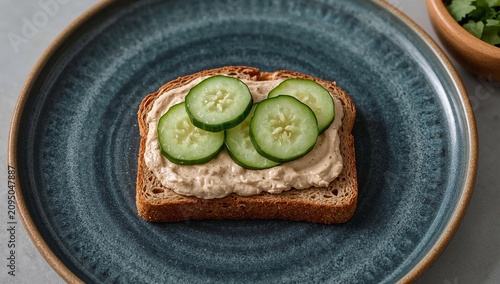 Tuna Salad on Bread With Sliced Cucumber Served on a Blue Plate
