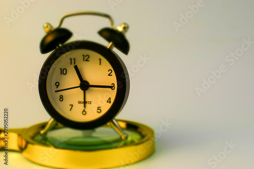 Canvastavla Vintage alarm clock sits atop magnifying glass