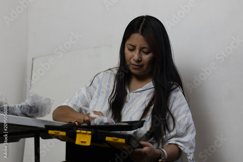 Foto Woman concentrating on organizing and selecting tools from her toolbox, preparin