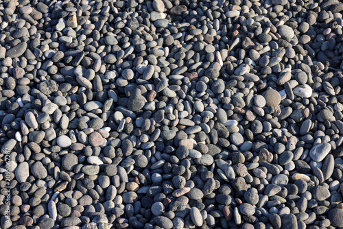Background of sea stones. Close-up of stones of different shapes and sizes on the beach