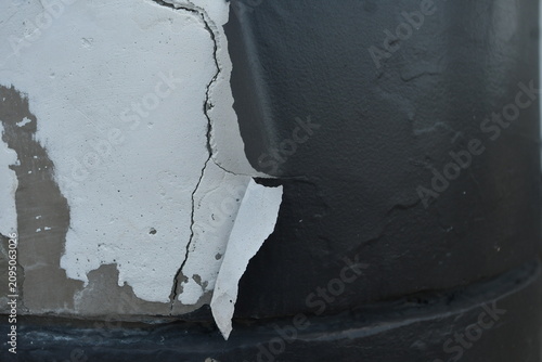 Peeling concrete wall with black paint texture