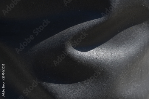 Dented black plastic close-up texture