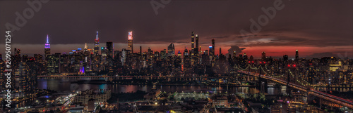 Φωτογραφία A dazzling night view of New York City skyline, showcasing iconic skyscrapers illuminated against a dramatic sunset