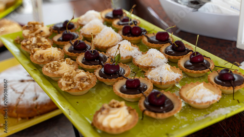 Canvastavla Assorted Mini Dessert Tartlets with Cherries on Buffet Table