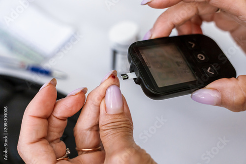 Bild auf Leinwand Macro view of inserting a blood glucose test strip into a digital glucose meter