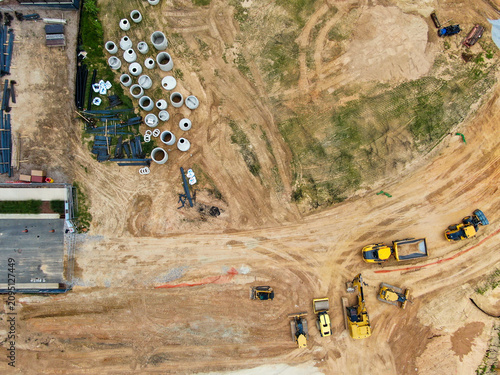 Aerial Top Down View of Infrastructure Site with Construction Equipment and Concrete Pipes