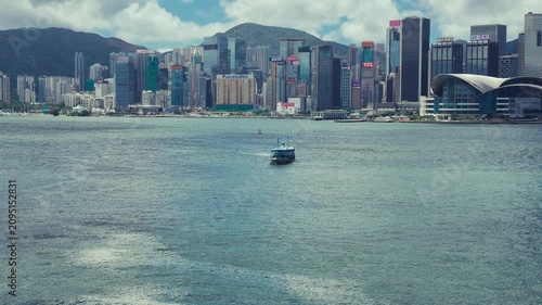 A panoramic view of Hong Kong's skyline with modern architecture blending seamlessly into the lush green hills and water