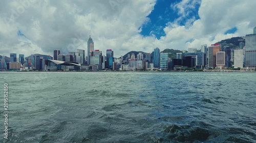 A serene view of Hong Kong's vibrant skyline seen from a moving boat.