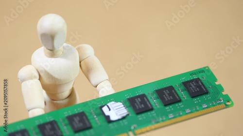Wooden artist mannequin presenting a green desktop RAM module before collapsing on beige background, computer memory shortage, rising hardware prices, supply crisis and financial pressure concept