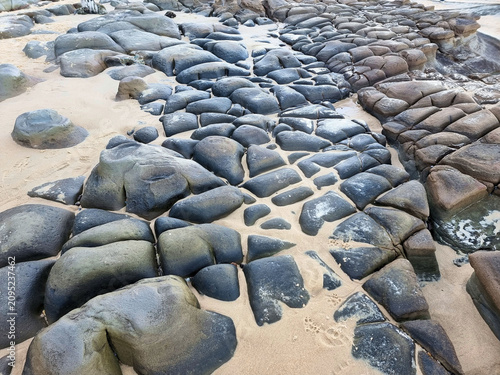 Highly eroded rocks on the rock platform on Susan Gilmore Beach Newcastle New South Wales Australia. Erosion has followed joint lines many are filled with sand